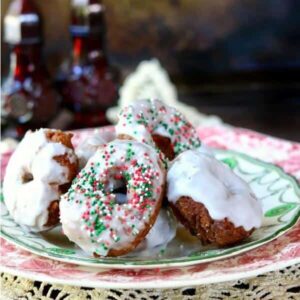 golden brown gingerbread donuts glazed with a white lemon glaze and sprinkled with red and green sprinkles