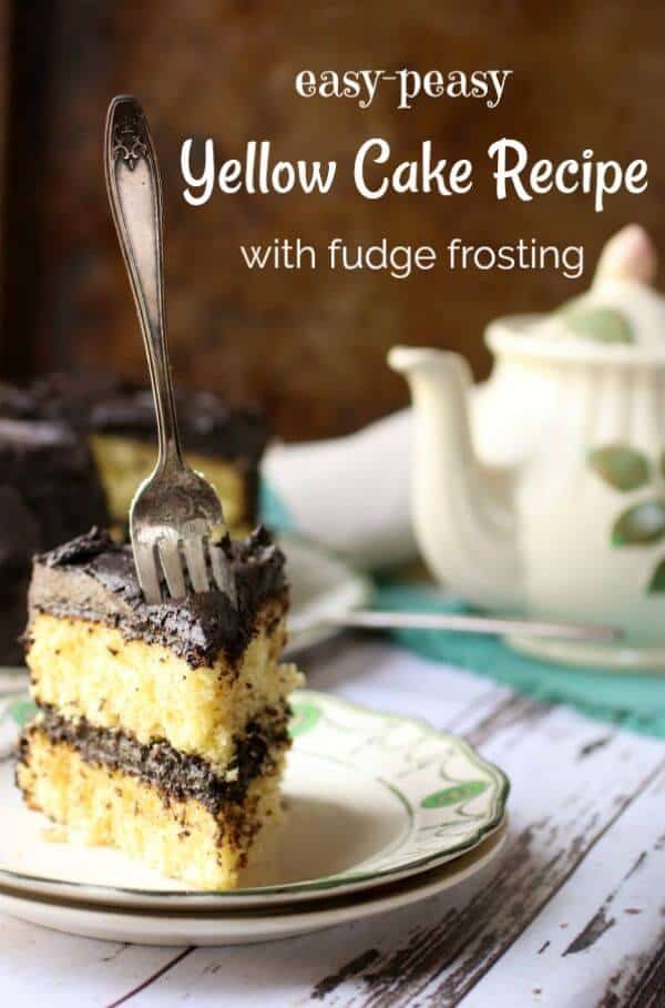 Title image for yellow cake recipe shows a slice of yellow layer cake with fudge filling and frosting on a plate. a sliver fork is thrust into the cake. An antique teapot is in the background.