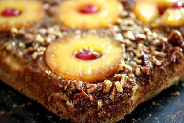 Close up image of pineapple upside down cake made from scratch. Pineapple rings have red cherries in the centers.