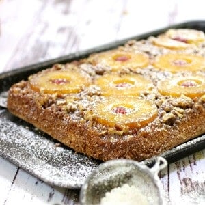 Uncut pineapple upside down cake dusted with confectioner's sugar.