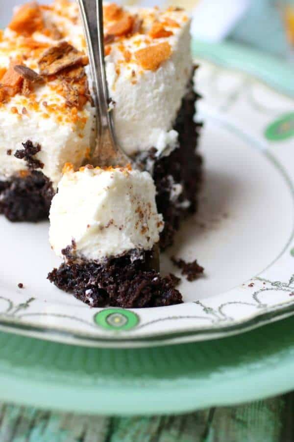 Closeup of a serving of chocolate holy cow cake with a silver fork stuck down into the cake