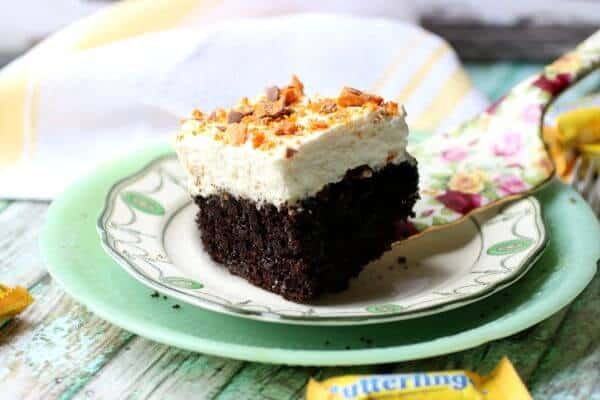 Featured image for holy cow cake - chocolate cake with whipped cream on top and chopped butterfingers candy bars sprinkled over all.