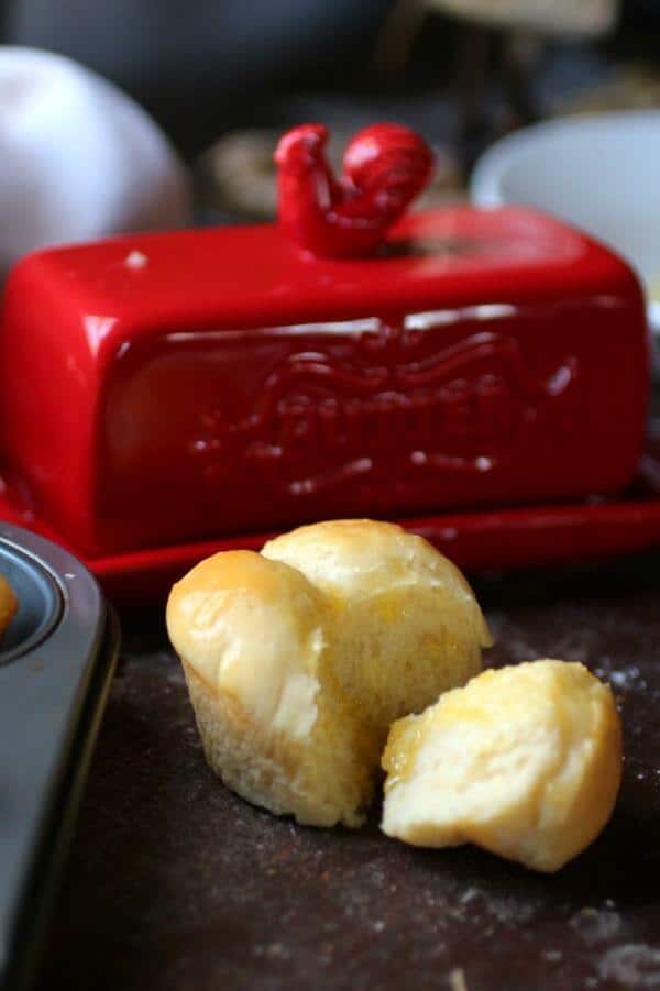 Buttery soft cloverleaf roll broken open on a table.