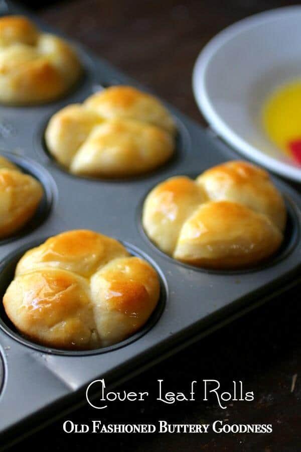 Golden brown cloverleaf rolls cooling in a pan.