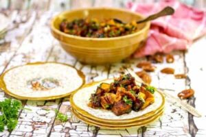 Golden sweet potatoes and pecans are diced into a salad and served on gold edged plates.