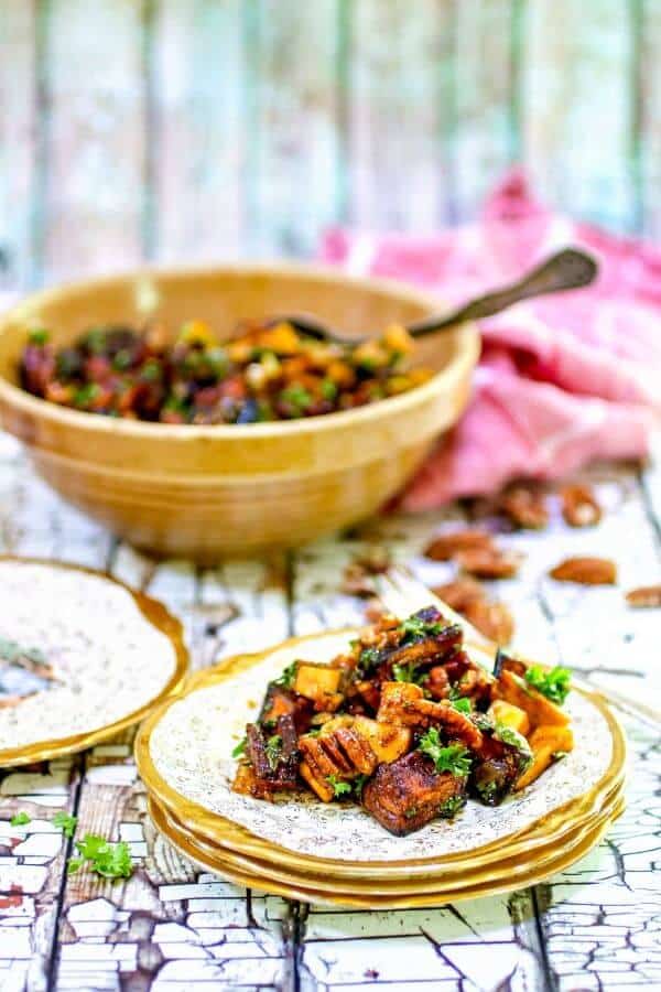 The sweet potato salad is served on a gold edged plate with an antique yellow ware bowl in the background.