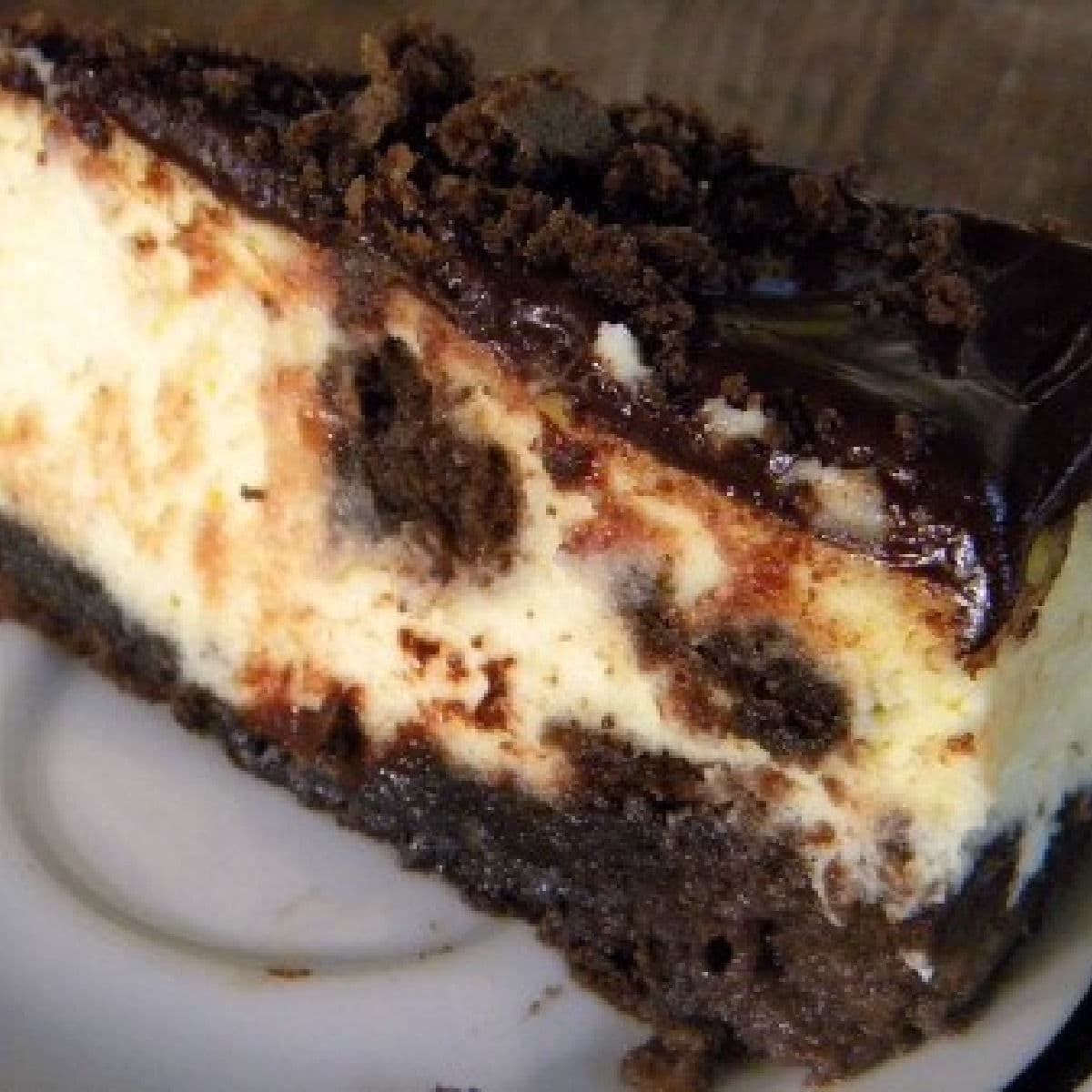 A slice of brownie cheesecake on a plate.