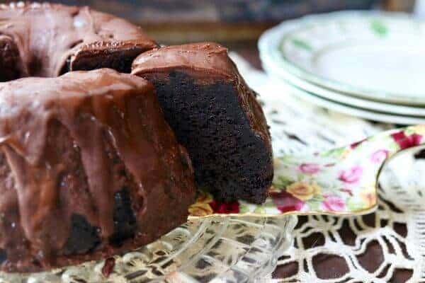 A serving of chocolate cake being removed from the cake plate.