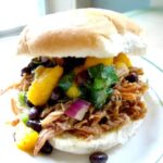 Pulled pork sandwich with mango salsa on top.