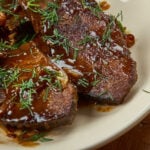 Closeup of grilled steaks showing the sauce.