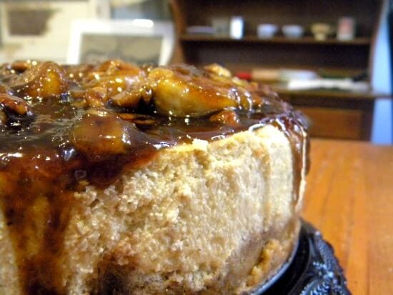 A closeup of cheesecake with a brown sugar and banana topping.