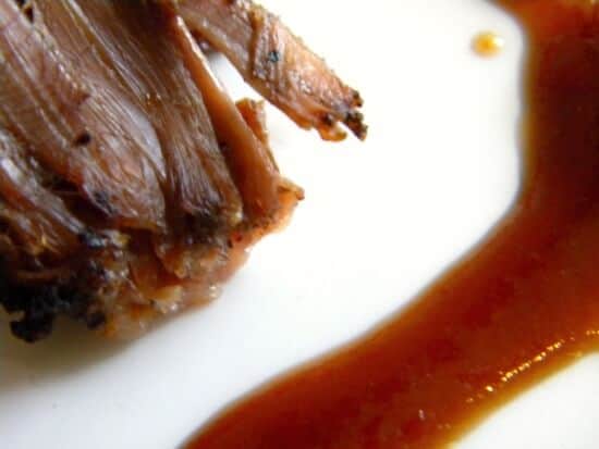 Closeup of brisket with bbq sauce on it.