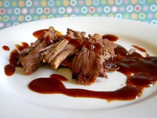 Plate of beef brisket with Dr Pepper bbq sauce on it.