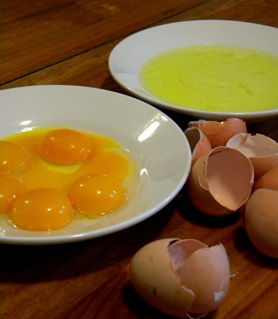 Egg yolks and whites separated into two bowls for chantilly cake.