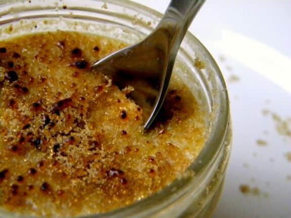 A spoon dipping into a jar of peanut butter custard.