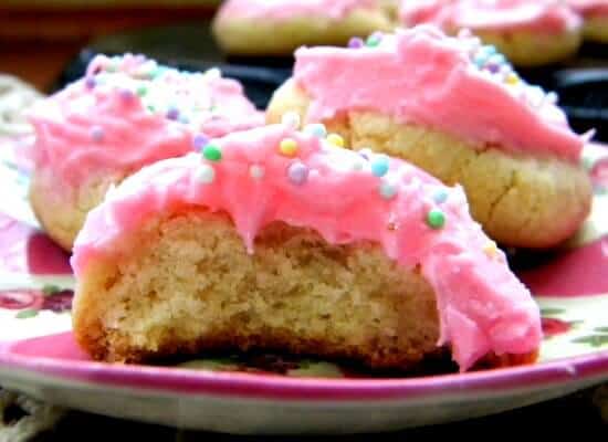 CLoseup of pink frosted sugar cookies broken open to see the tender inside.