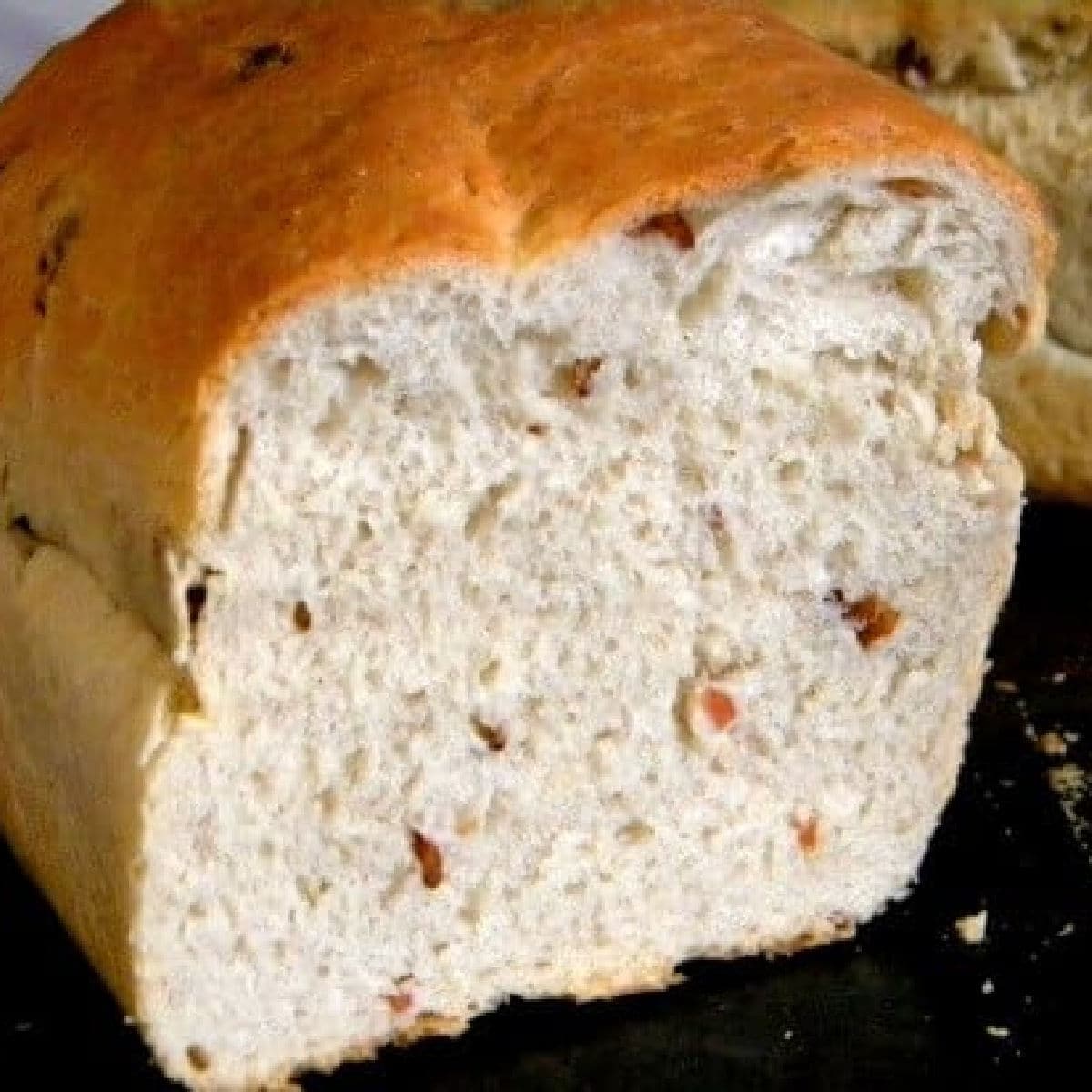 A loaf of bacon bread that has been sliced open to show the inside texture.