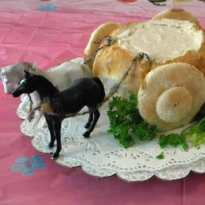 A round loaf of bread filled with dip made to look like a Cinderella coach.