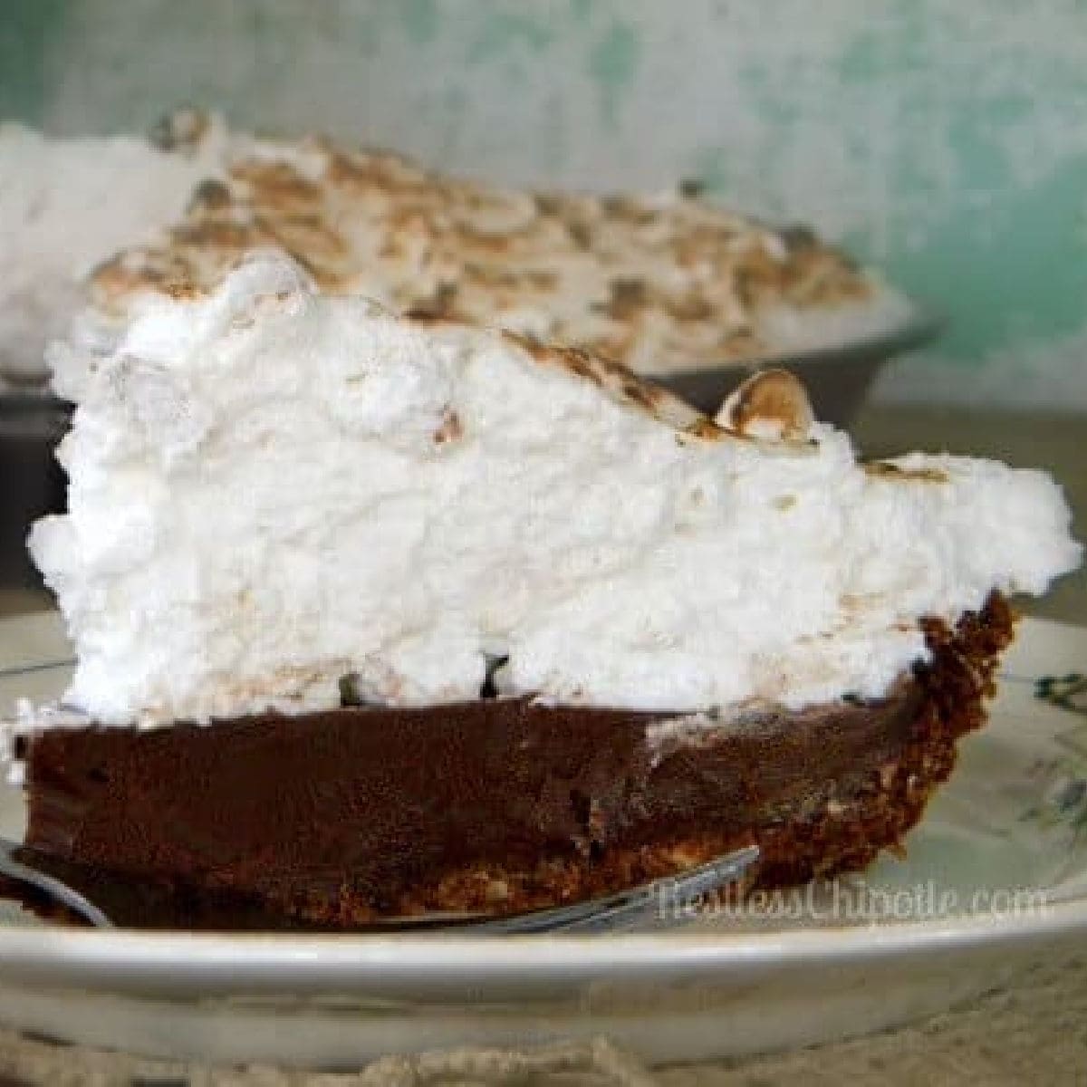 A closeup of a slice of chocolate pie showing layers of chocolate and meringue.