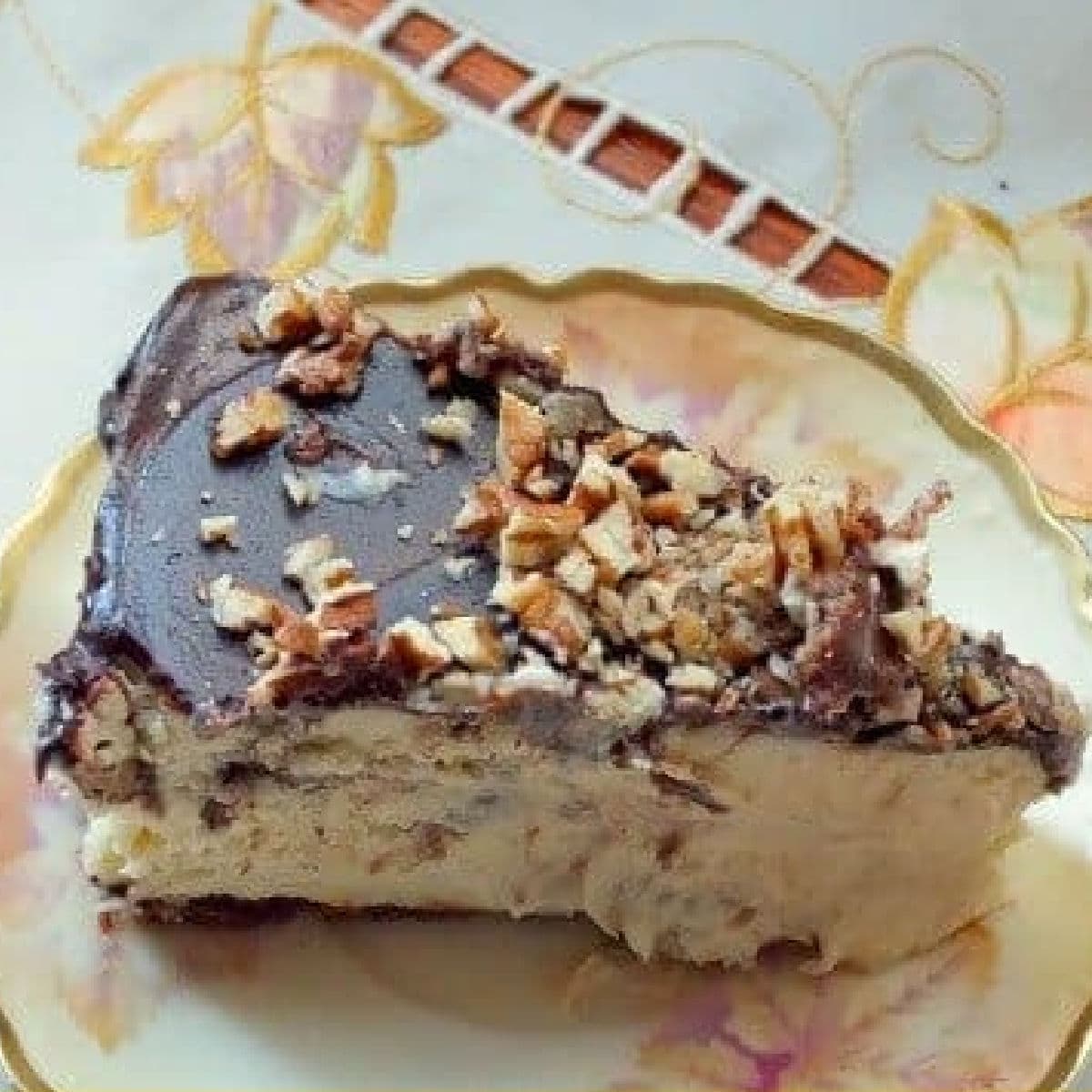 A slice of chocolate covered cheesecake on a plate.