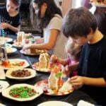 kids decorating gingerbread houses at a gingerbread house party