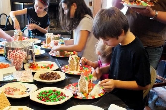 kids decorating gingerbread houses at a gingerbread house party