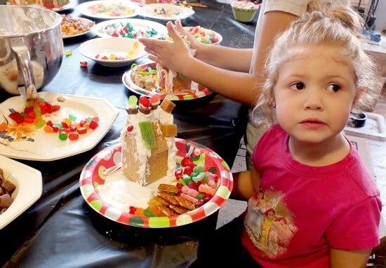 a toddler makes a house at a gingerbread house party 