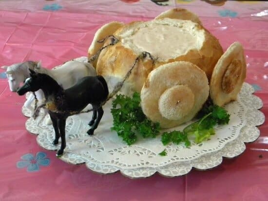 A round loaf of bread that has been hollowed out and filled with dip then decorated to look like a coach.