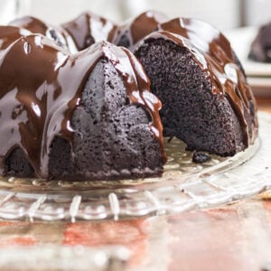 A closeup of chocolate bundt cake on a cake plate.