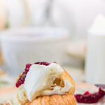 Side view of a croissant with jam and cream. Text overlay for Pinterest.