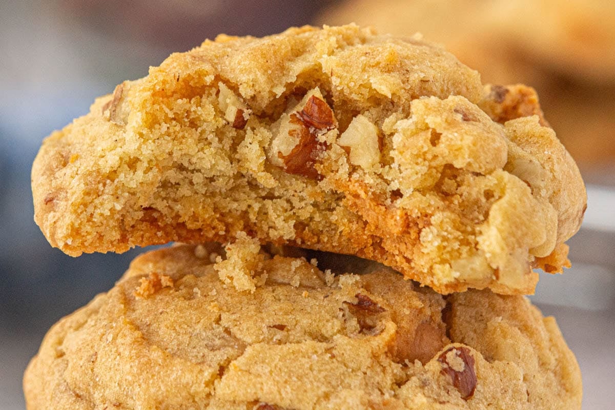 Closeup of a butter pecan toffee cookie with a bite removed.