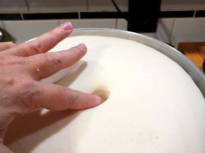 a finger pushed in the bread dough to test the rise.