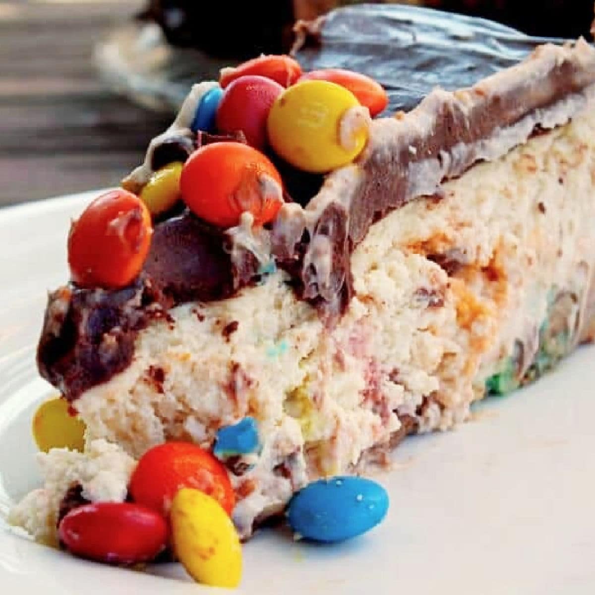 Closeup of a slice of m and m cheesecake.