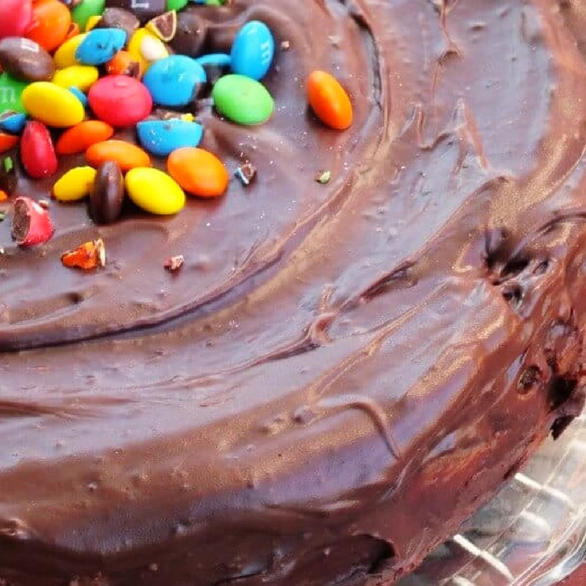 Closeup of the top of the m & m cheesecake showing chocolate glaze.