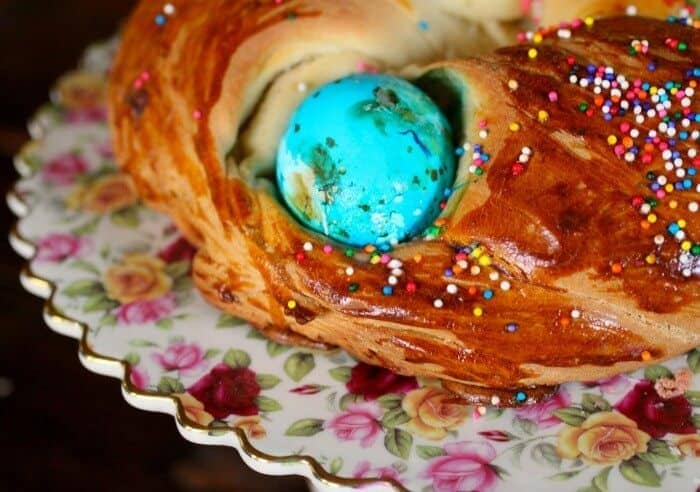 A finished wreath of Easter bread with a blue Easter egg on top.