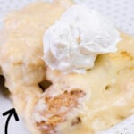 Side view of a scoop of banana pudding with whipped cream on top.