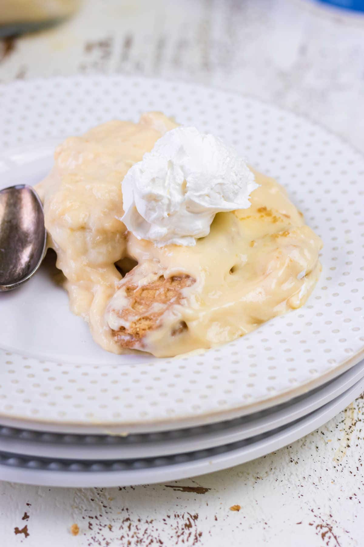 Closeup of banana pudding on a plate with a dollop of whipped cream.