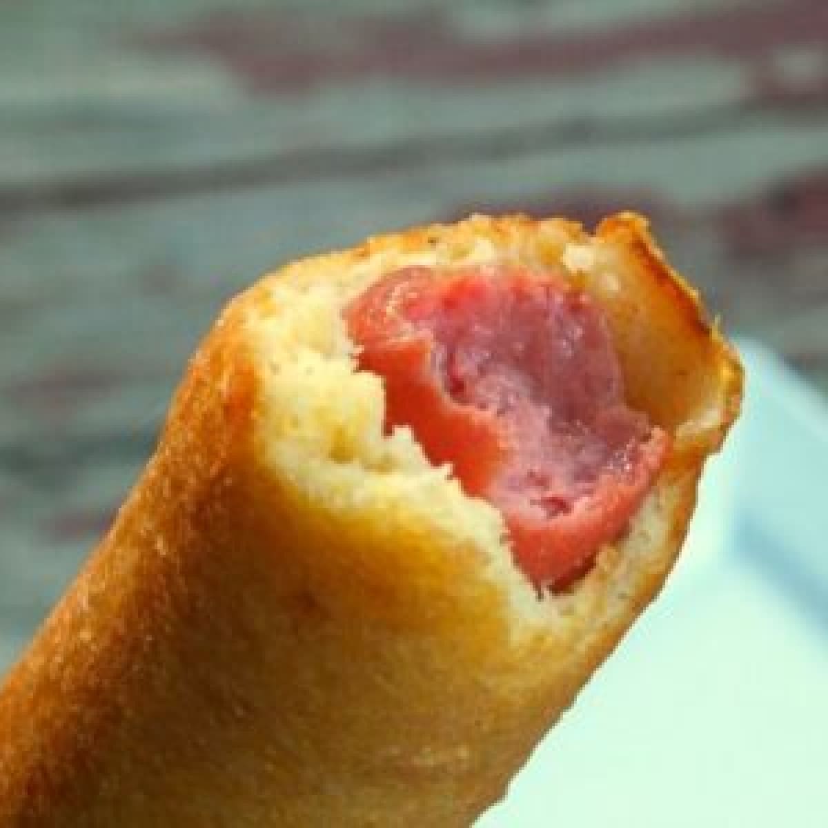 A corndog with a bite taken out of it.