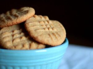 Closeup of peanut butter cookies in a blue bowl showing texture.