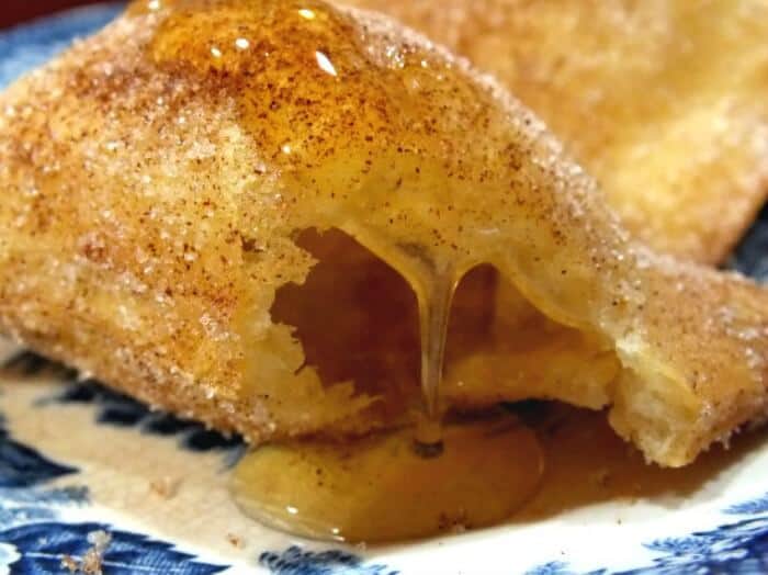 A close up of spicy sopapillas drizzled with honey.