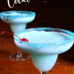 Two cocktails on a table with a black background and text overlay for Pinterest.