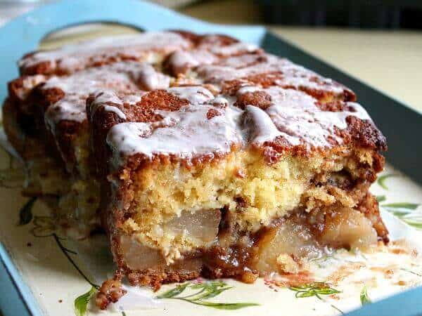 Loaf of apple bread sliced open to show tender apples inside.