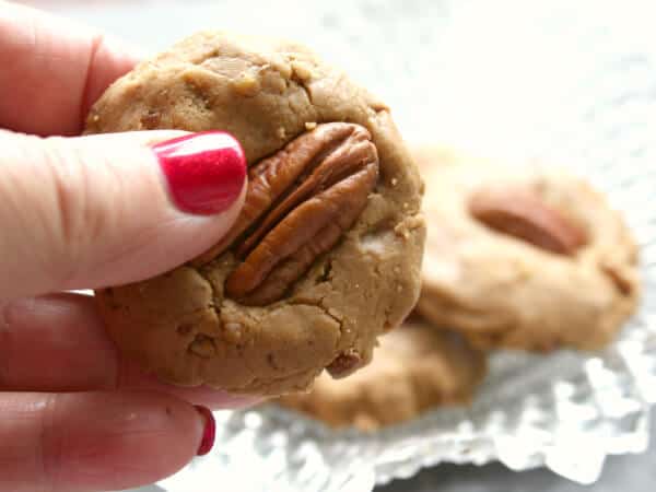 homemade pecan praline being held in the fingers.