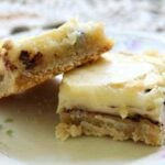 Bar cookies topped with cream cheese on a plate.