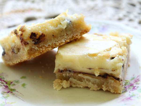 Bar cookies topped with cream cheese on a plate.