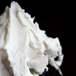 White wedding cake frosting on a whisk.