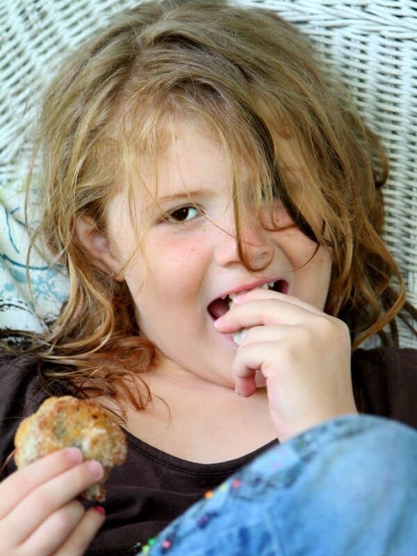 A little girl eating fried oreos.