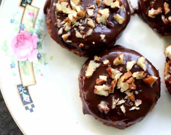 Overhead view of cookies covered in shiny chocolate glaze with pecans on top.