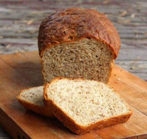 Loaf of bread sliced on a bread board.