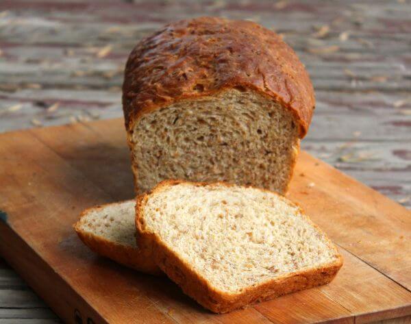 Loaf of bread sliced on a bread board.